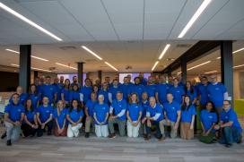 A large group of people wearing matching tshirts are posed for a photo