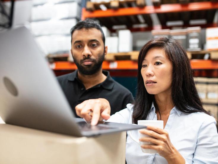 A man and woman are looking at a computer screen
