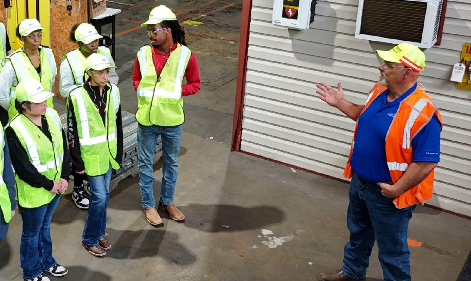 A manufacturing supervisor leading their team during a manufacturing and operations job onboard training tour at a Saint-Gobain North America facility. 